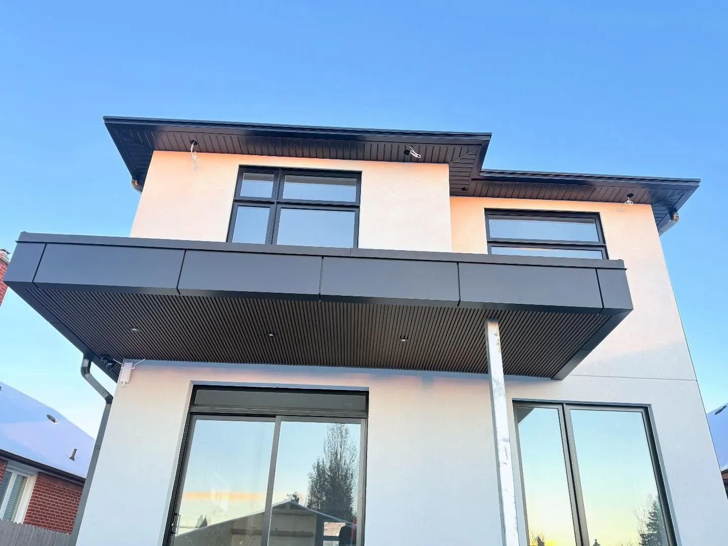 Full exterior package — ACM panels, soffit, fascia, custom square gutters and downpipes, fluted PVC panels, 26-gauge textured black cap flashing